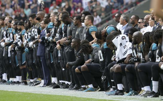 Jugadores se arrodillan mientras suena el himno nacional estadounidense Jugadores se arrodillan mientras suena el himno nacional estadounidense