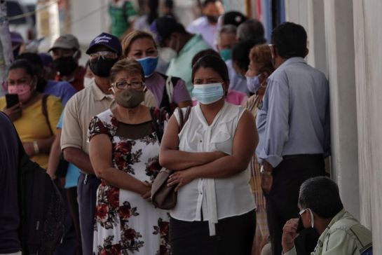 Personas esperan para poder ingresar al banco Personas esperan para poder ingresar al banco