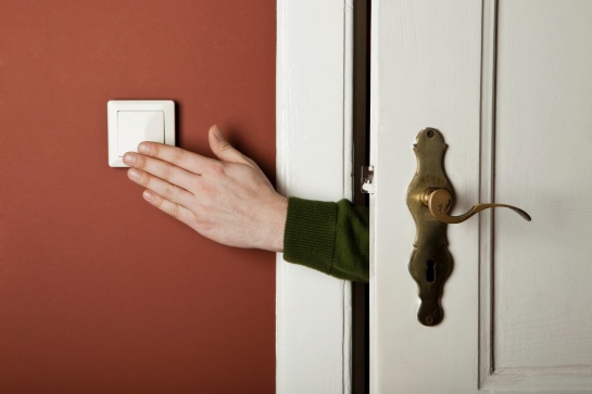 Foto de hombre apagando la luz del cuarto para no gastar luz Foto de hombre apagando la luz del cuarto para no gastar luz